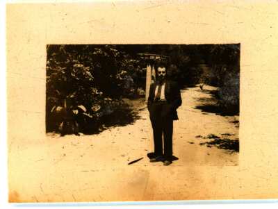 Retrato de Plano General de hombre vestido de terno y corbata en un camino rodeado de vegetación