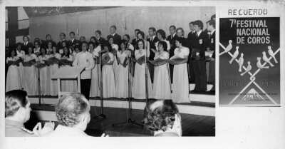 Plano general de un grupo coral cantando sobre una tarima. Está compuesto por Hombres y Mujeres quienes están formados en tres hileras junto al Director del coro, Alfredo von Edelsberg. 

Se encuentran en el VII festival de coros, celebrado en La Unión por la federación de coros de Chile