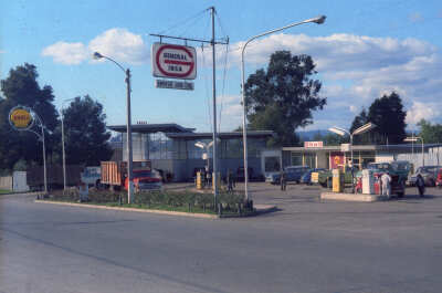 Plano general de una estación de servicio de la empresa Shell con un conjunto de autos haciendo fila en su interior