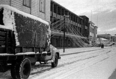 Camión cubierto de nieve transitando por una avenida Prat nevada en dirección norte, a la altura de la municipalidad