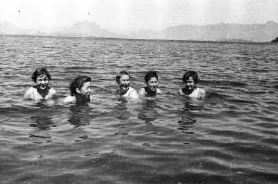 plano general de un grupo de Mujer y un niño sumergidos en el agua mientras se ríen durante un paseo familiar en el lago