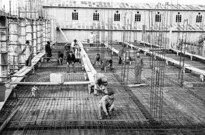 PGE de un grupo de Hombres trabajando, la mayoría se encuentra trabajando hincado sobre las mallas de enfierraduras de lozas de la construcción del costado izquierdo del edificio municipal de La Unión