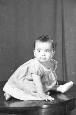 Retrato de estudio de Plano medio de niña Bebé sentada en una mesa mirando de Medio perfil