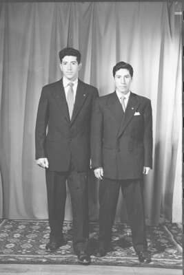 Retrato de estudio de Plano entero de dos hombres con Trajes de pie mirando hacia el frente