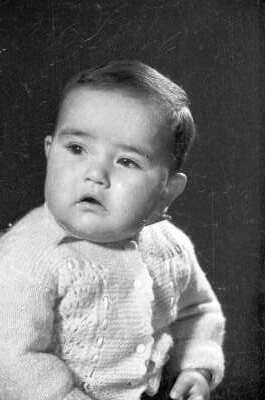 Retrato de estudio de Plano medio de Bebé sentado con chaleco de lana, mirando hacia el lado