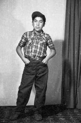 Retrato de estudio de Plano entero de niño con camisa, pantalón y boina, de pie con manos en los bolsillos