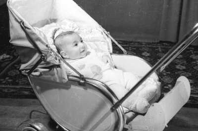 Retrato de estudio de Plano entero de un bebé de perfil, sobre su coche