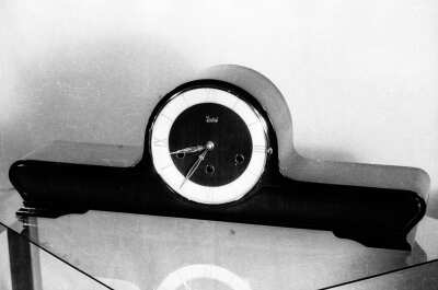 Plano entero de un reloj de Medio perfil sobre una mesa de vidrio. Lugar no identificado