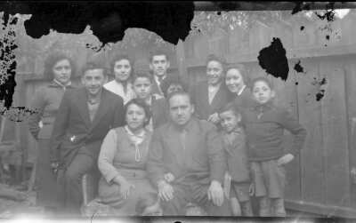 Plano medio de un grupo de personas sentadas o de pie posando alegremente en un patio